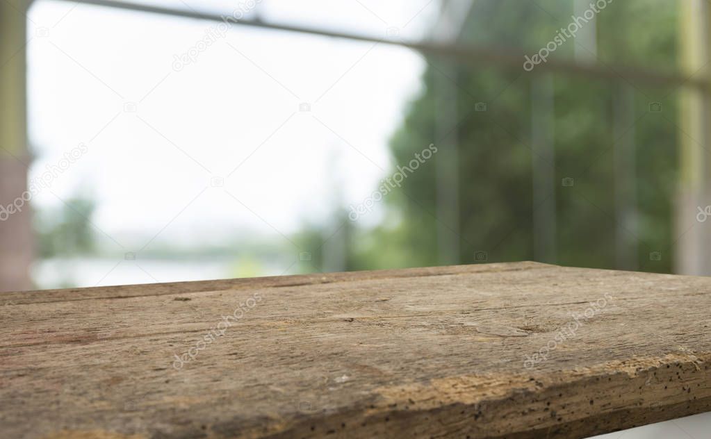 Empty of wood table top on blur of curtain with window view green from tree garden background.For montage product display or design key visual layout