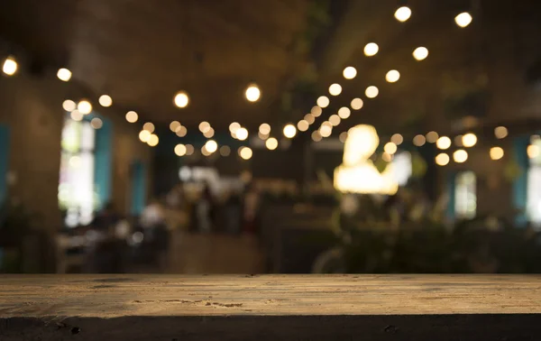 Порожня дерев'яна стільниця на розмитому світлому золотому боке ресторану кафе на темному фоні — стокове фото