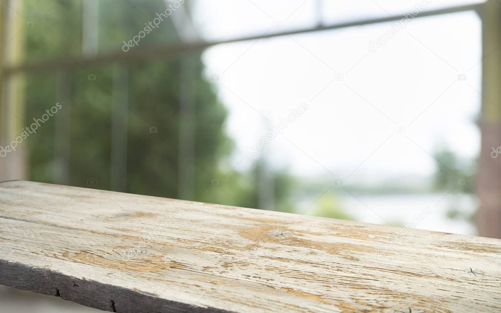 Empty of wood table top on blur of curtain with window view green from tree garden background.For montage product display or design key visual layout