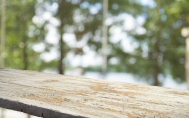 Ağaç bahçe arka planda pencere görünümü yeşil ile perde bulanıklık üzerinde ahşap masa üst boş. Montaj ürün gösterimi veya tasarım anahtarı görsel düzeni için