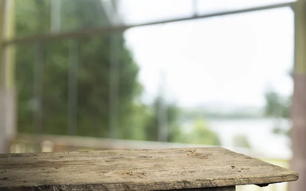 ツリーガーデンの背景からウィンドウビューの緑とカーテンのブラーに木製のテーブルトップの空。モンタージュ製品のディスプレイまたはデザインキーのビジュアルレイアウト — ストック写真