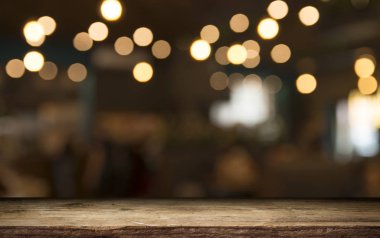 Karanlık arka planda kafe restoranın bulanıklık ışık altın bokeh boş ahşap masa üstü