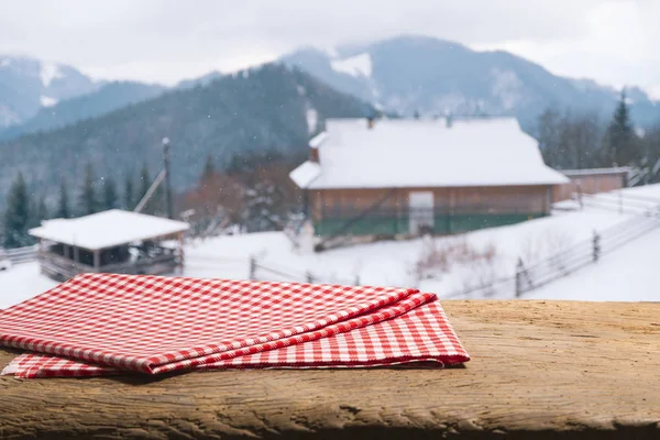 Boş ahşap döşeme üzerinde kış arka plan bulanık. Nesneniz için boş alanı. Zemin, kış manzarası ve kar taneleri ile Tablo düzeni.