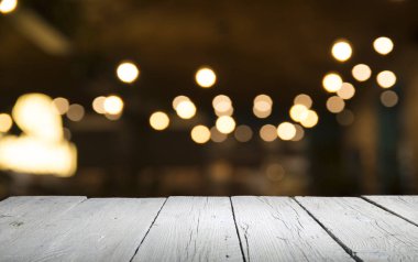 Karanlık arka planda kafe restoranın bulanıklık ışık altın bokeh boş ahşap masa üstü