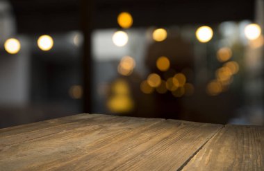 Karanlık arka planda kafe restoranın bulanıklık ışık altın bokeh boş ahşap masa üstü