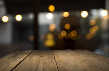 Karanlık arka planda kafe restoranın bulanıklık ışık altın bokeh boş ahşap masa üstü