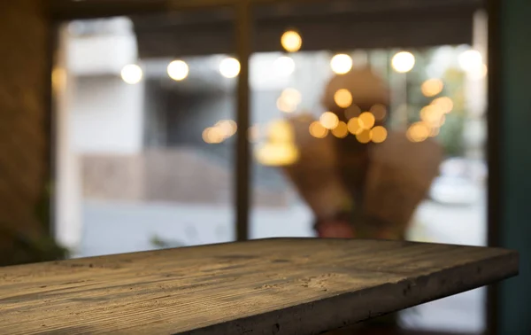 Tapa de mesa de madera vacía en borroso bokeh oro claro de restaurante cafetería en fondo oscuro — Foto de Stock