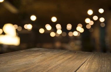 Karanlık arka planda kafe restoranın bulanıklık ışık altın bokeh boş ahşap masa üstü