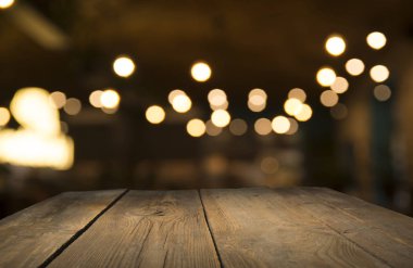 Karanlık arka planda kafe restoranın bulanıklık ışık altın bokeh boş ahşap masa üstü