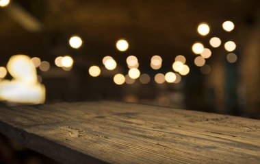 Karanlık arka planda kafe restoranın bulanıklık ışık altın bokeh boş ahşap masa üstü