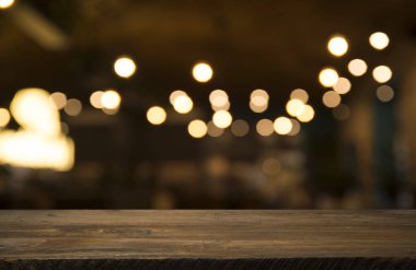 Karanlık arka planda kafe restoranın bulanıklık ışık altın bokeh boş ahşap masa üstü