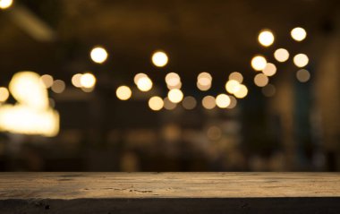 Karanlık arka planda kafe restoranın bulanıklık ışık altın bokeh boş ahşap masa üstü