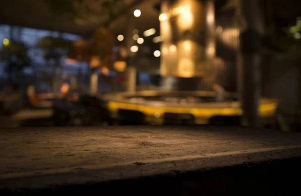 Empty wood table top on blur light gold bokeh of cafe restaurant in dark background — Stock Photo, Image
