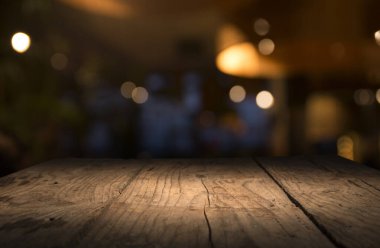Karanlık arka planda kafe restoranın bulanıklık ışık altın bokeh boş ahşap masa üstü
