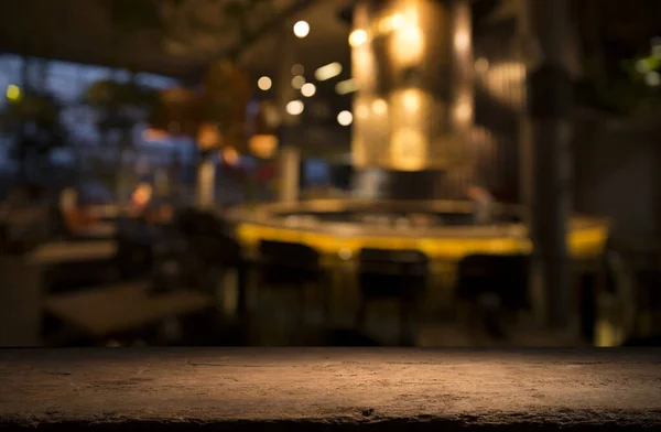 Empty wood table top on blur light gold bokeh of cafe restaurant in dark background — Stock Photo, Image
