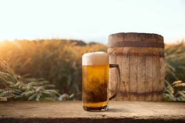 Buğday tarlasının üzerinde gün batımı ya da gün doğumu olan boş ahşap bir masa. Ürün montajı için hazır