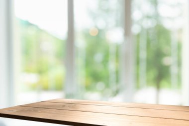 Perde arkaplan ile kapatılmış penceredeki ahşap masa