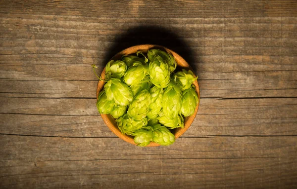 Beer. Still life with Vintage beer barrel and glass light beer. Fresh amber beer concept. Green hop and gold barley on wooden table. Ingredients for brewery. Brewing traditions