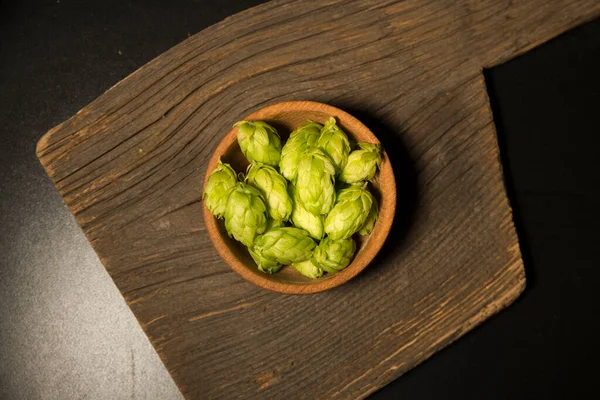 Beer. Still life with Vintage beer barrel and glass light beer. Fresh amber beer concept. Green hop and gold barley on wooden table. Ingredients for brewery. Brewing traditions