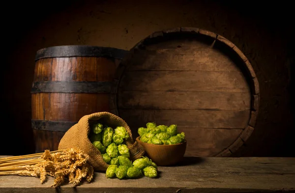 ビールだ ヴィンテージビールバレルとガラスライトビールとまだ生活 新鮮な琥珀色のビールのコンセプト 木製のテーブルの上に緑のホップと金の大麦 醸造所の原料 醸造の伝統 — ストック写真