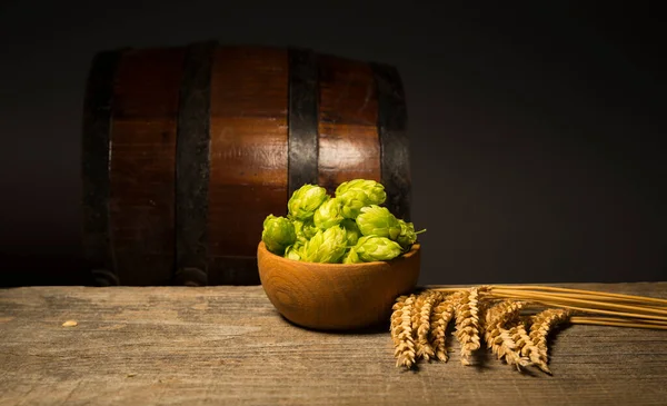 Bier. Stillleben mit Vintage-Bierfass und Glas Light-Bier. Frisches bernsteinfarbenes Bier. Grüner Hopfen und Goldgerste auf dem Holztisch. Zutaten für Brauerei. Brautradition — Stockfoto