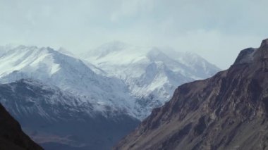Bulutlardaki karlı dağların zirveleri Pamir Tacikistan 