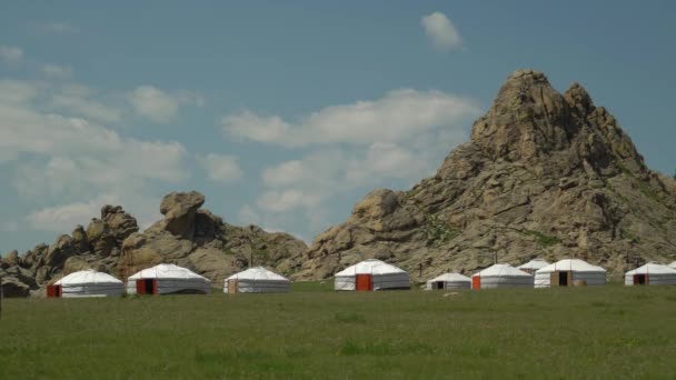 Yurts em um vale verde no fundo de rochas — Vídeo de Stock