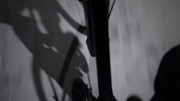 Homem monta uma bicicleta pedal vista sombra de uma bicicleta, noite — Vídeo de Stock