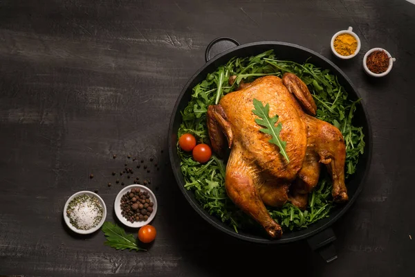 Pollo intero arrosto o tacchino servito in padella di ferro Posizionato su fondo nero Fotografia Stock