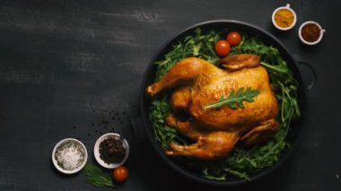 Lezzetli kızarmış tavuklar koyu arkaplan manzaralı bir tabakta dönerler.