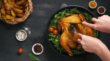 Kızarmış tavuk doğranmış tavuk, arka planda siyah bir arka planda çatal ve bıçakla doğranır.