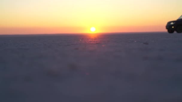 Car rides on a flat sandy surface against the background of dawn — Stock Video