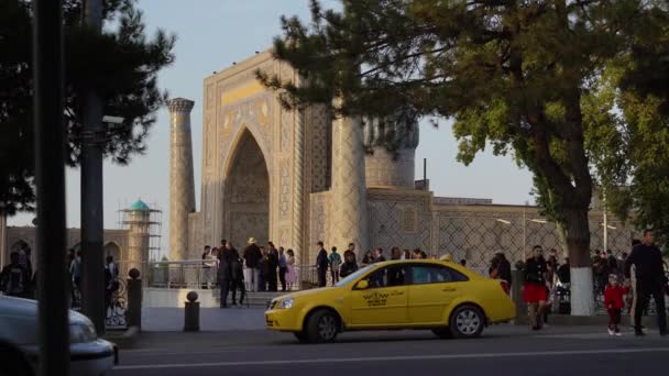 Samarkand, Uzbekistan, 2,09,2019：Samarkand street, yellow taxi at the Registan tourist site — 图库视频影像