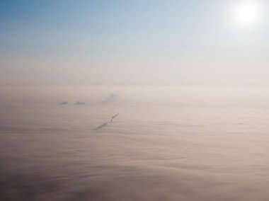 Bulutlarda şehrin hava manzarası. Bulutların sisli olduğu fabrikanın bacası. Yüksek kalite fotoğraf