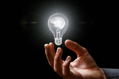 Akıllı karanlık bir arka plan üzerinde elinde yanan ampul. Beyin fırtınası sonucunda fikir kavramı.