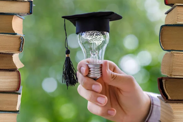 Öğrenci ampul cap altında arka plan bulanık akademik gösterir.