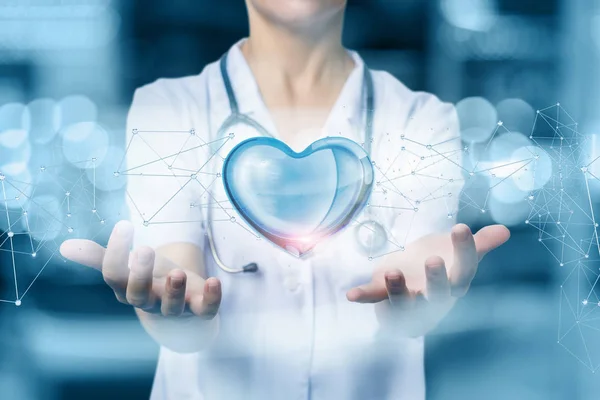 Doctor or nurse protects heart on blurred background.