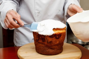 İşçi özlüyor bir spatula ile karanlık bir arka plan üzerinde kremalı pasta yemek.