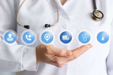Bir doktor ile bir stetoskop tıbbi sembolleri içinde bulunan küçük küreler yapısını tutuyor. Farklı tıbbi eğilimleri arasındaki etkileşimin bir kavramdır.