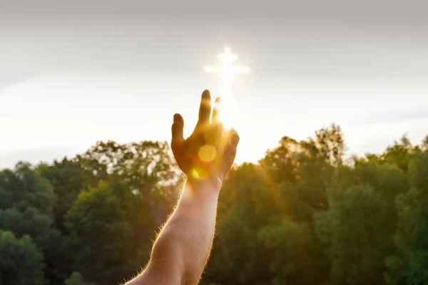 Рука Досягає Яскравого Зображення Хреста Яке Розташоване Небі Над Зеленими — стокове фото