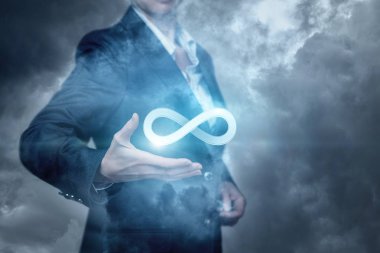 Bir iş kadını sonsuzluk işareti sis arka planı tutuyor. Yenilik düşünce sınırsız bir kavramdır.