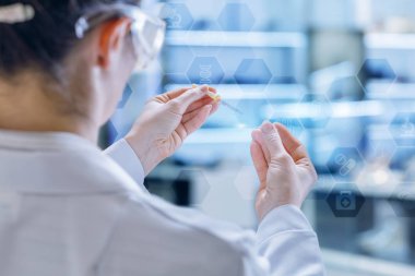 Bir laboratuar asistanı pipet ve cam yüzey laboratuvar iç arka plan kullanarak bazı araştırmalar, çalışıyor. Laboratorian araştırmacılar bir kavramdır.