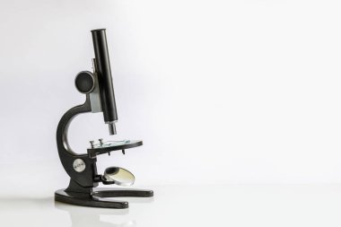 Çalışma yüzeyinde bazı madde mikroskopla düz beyaz alan üzerinde duruyor. Araştırma laboratorian ekipman bir kavramdır.