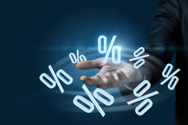 Проценты летают вокруг руки бизнесвумен на тёмном фоне. Принцип финансового процесса
.