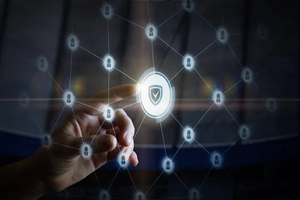 A man is touching the digital system of connections consisted of padlock icons and a shield in the middle. The concept is the security system principle.