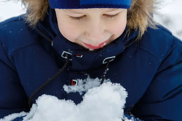 Szczęśliwy Uśmiechnięty Chłopiec Patrzy Stercie Śniegu Ręku Cieszyć Się Rozrywką — Zdjęcie stockowe