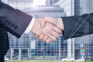 İşadamları ortaklarının bir yakın çekim ön planda bir büyüme diyagramı görüntü ile bulanık büyük şehir ofis merkezi arka planda el sıkışıyor. Başarılı anlaşma kavramı.