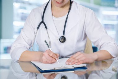 Bir closeup masada oturan ve bir reçete bulanık hastane Oda arka plan yapma doktor. Pratik tıp kavramı.