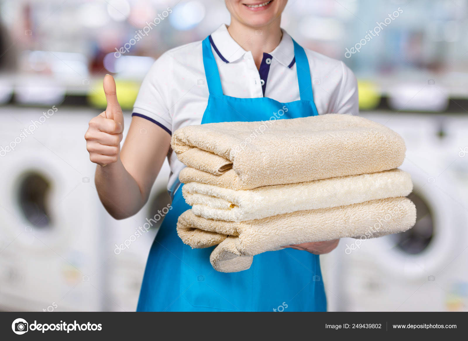 A laundry worker is holding clean towels. — Stock Photo © NataliMis 249439802