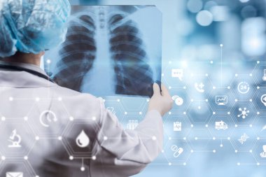 Arka ayakta ve tedavi ve tanı için akciğerler görüntü tutan bir doktor.